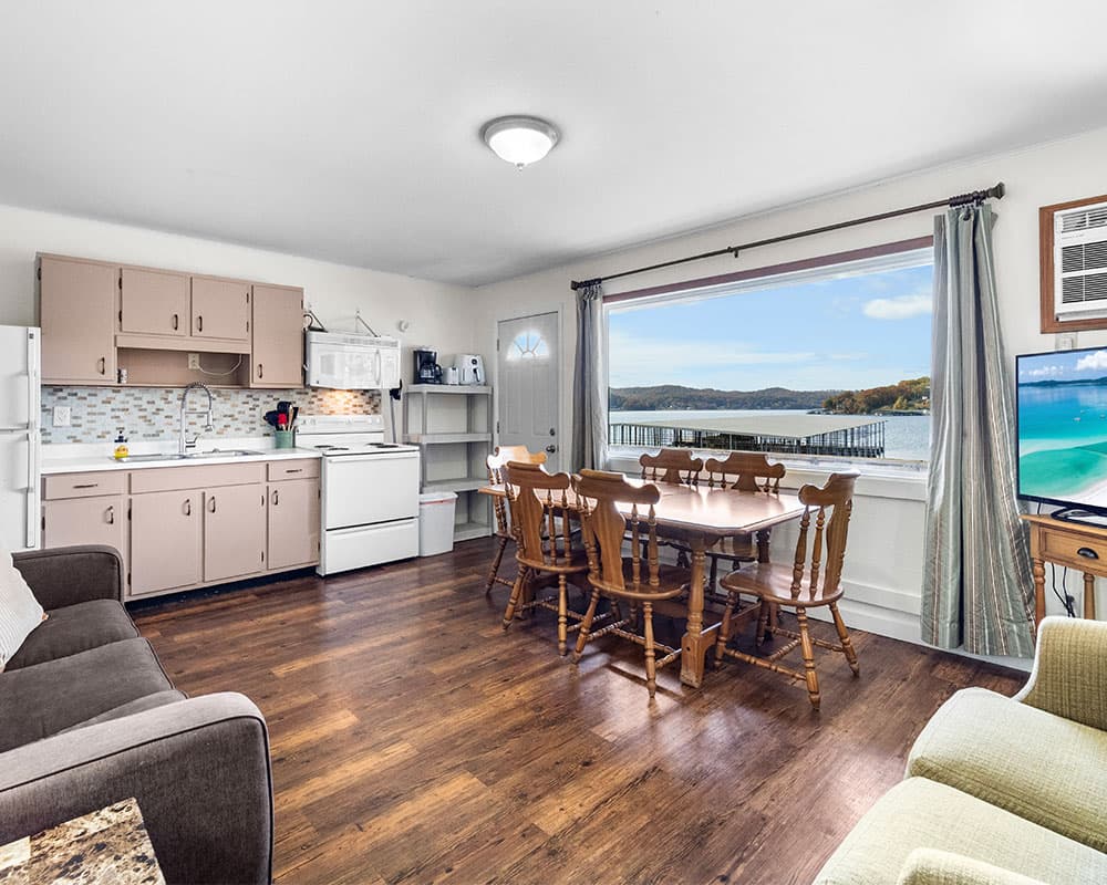 A cozy, light-filled kitchen and dining area with a scenic view of a lake.